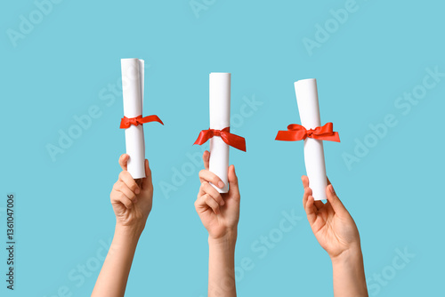 Cuadro en lienzo Female hands with diplomas on blue background