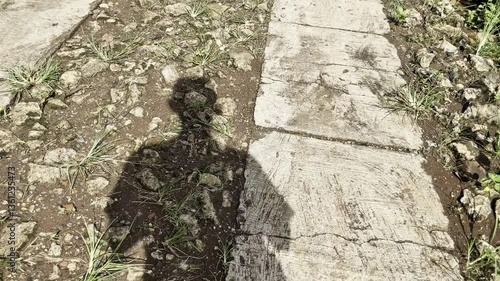 Shadow walk on concrete pathway with two lanes