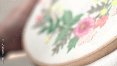 Beautiful embroidery flowers on cotton fabric. Product of needlework on a piece of embroidery. Needlework is decorative sewing and textile arts handicrafts. How to stitch embroider flowers on clothes.