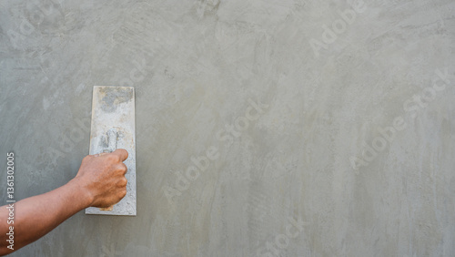 Hand plasterer plastering gray cement wall background, Hand worker brush polish rough concrete wall for smooth manual well free space for text with occupations about building construction