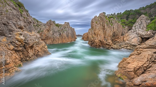 Dramatic coastal scene featuring a narrow channel between towering rock formations, showcasing a mesmerizing blend of land and sea.