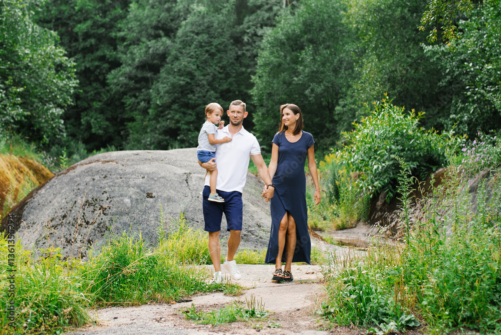 Parents And Child Holding Hands On Green Trail