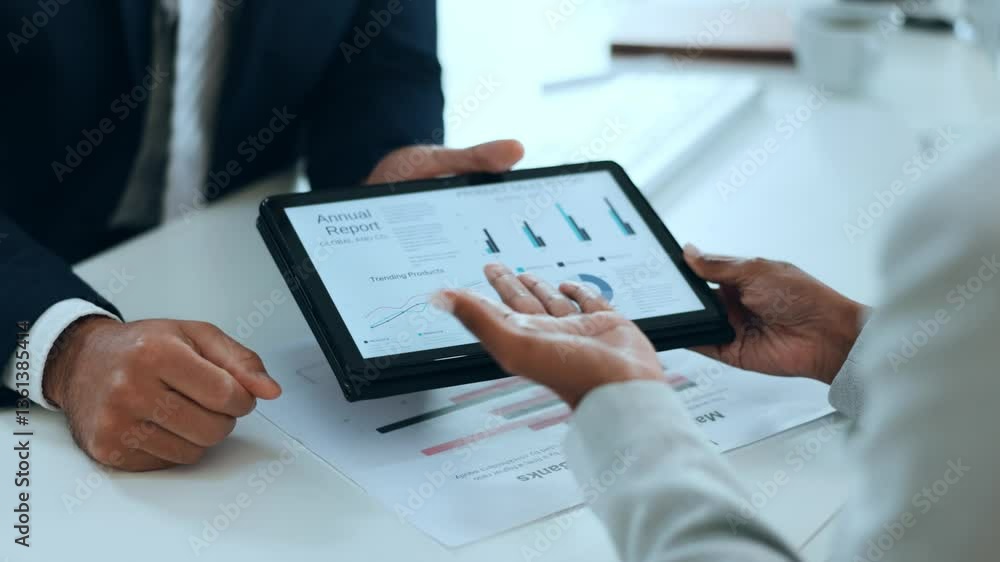 Business partner shows project statistics on a tablet Business partner shows project statistics on a tablet