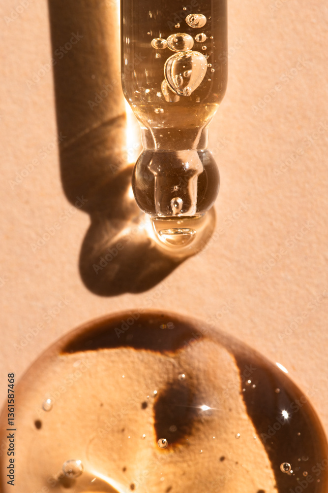 Obraz premium Pipette with a drop of liquid product, hyaluronic acid, essential oil on a beige background, top view, macro.
