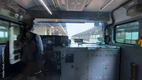 Train operator inside the cockpit of a high-speed train approaching a station in Tokyo