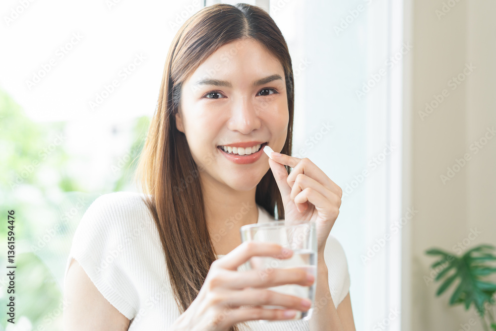 Dietary supplement, healthy positive asian young woman hand holding herb pill, take vitamin nourish body for treatment beauty skin, taking medicine with glass of water at home. Health care concept. Dietary supplement, healthy positive asian young woman hand holding herb pill, take vitamin nourish body for treatment beauty skin, taking medicine with glass of water at home. Health care concept.