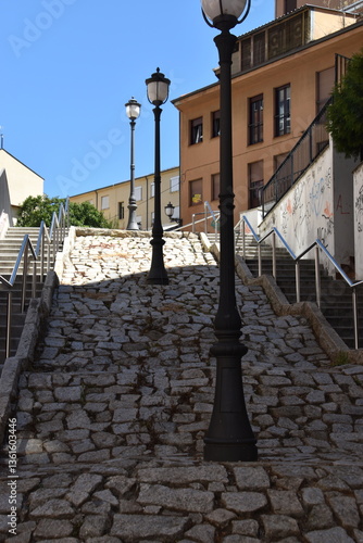 Calle empedrada con farolas en medio