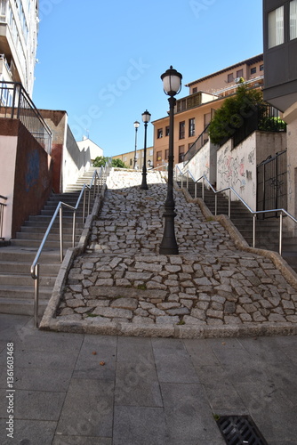 Calle empedrada con farolas en medio