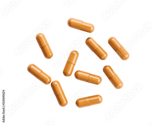 scattered turmeric capsules isolated on white background