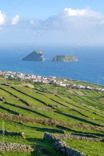 Obraz na płótnie Agricultural fields divided by stone walls, with the village of Feteira and the Goat Islands in the background, on the island of Terceira, Azores, Portugal. w salonie