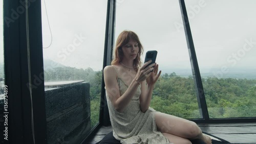Wallpaper Mural Woman using smartphone in modern house during rain Torontodigital.ca