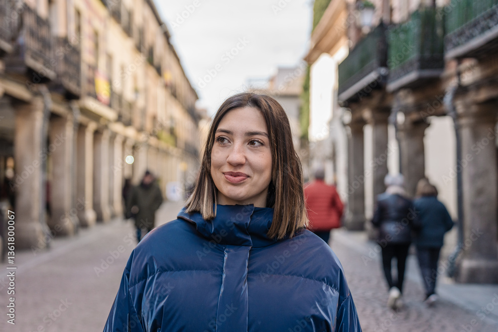 Fototapeta premium Young woman smiling walking down the street in historic city center