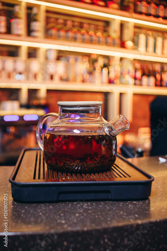 Traditional artisan tea in transparent teapot on bar counter