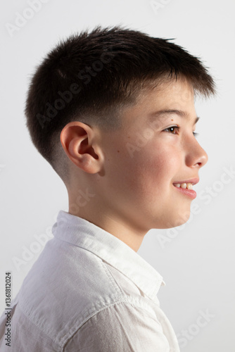 Smiling 11-year-old Caucasian boy in a white shirt
