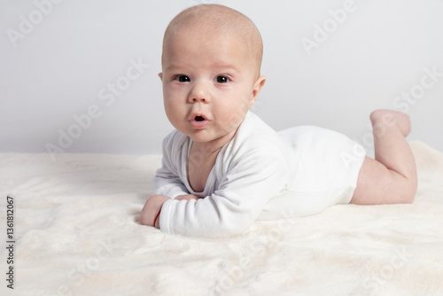 Three-month-old baby lying on a soft blanket