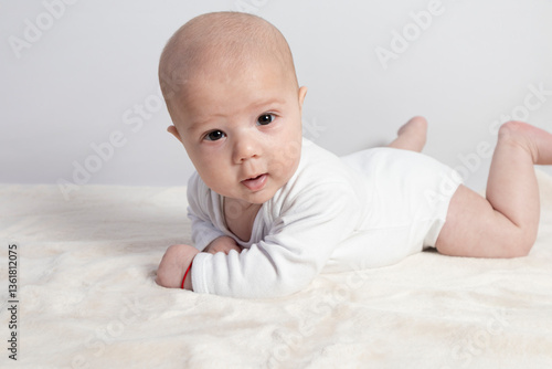 Three-month-old baby lying on a soft blanket