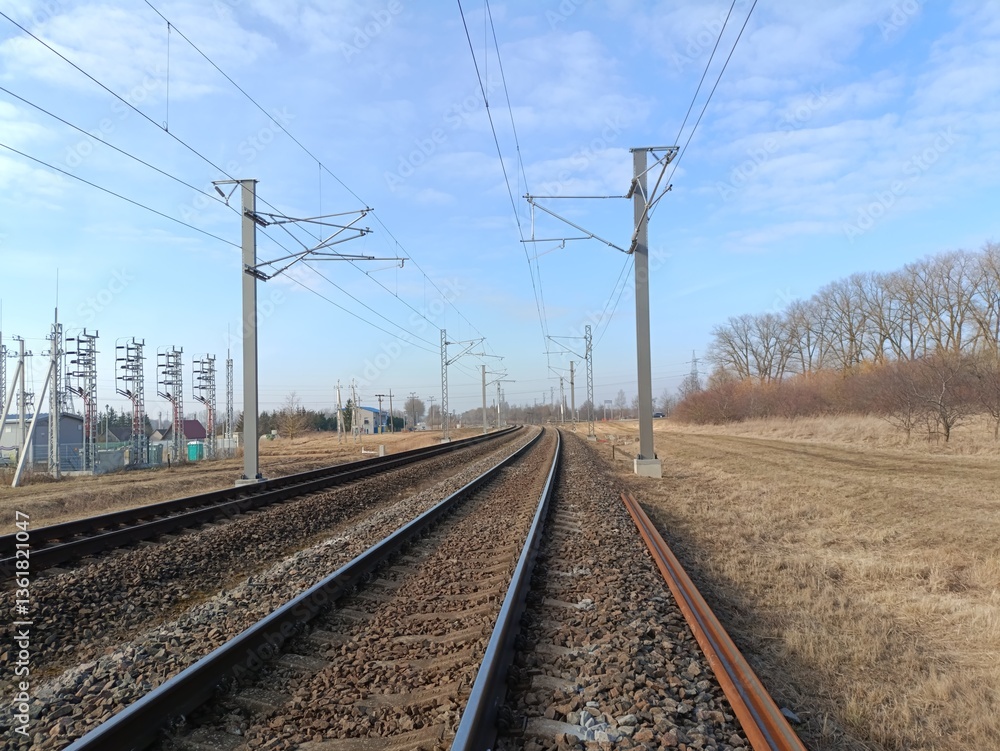 Two way railroad tracks in countryside. Two railway tracks. Sunny day. Countryside. Fields and trees. Two way railroad tracks in countryside. Two railway tracks. Sunny day. Countryside. Fields and trees.