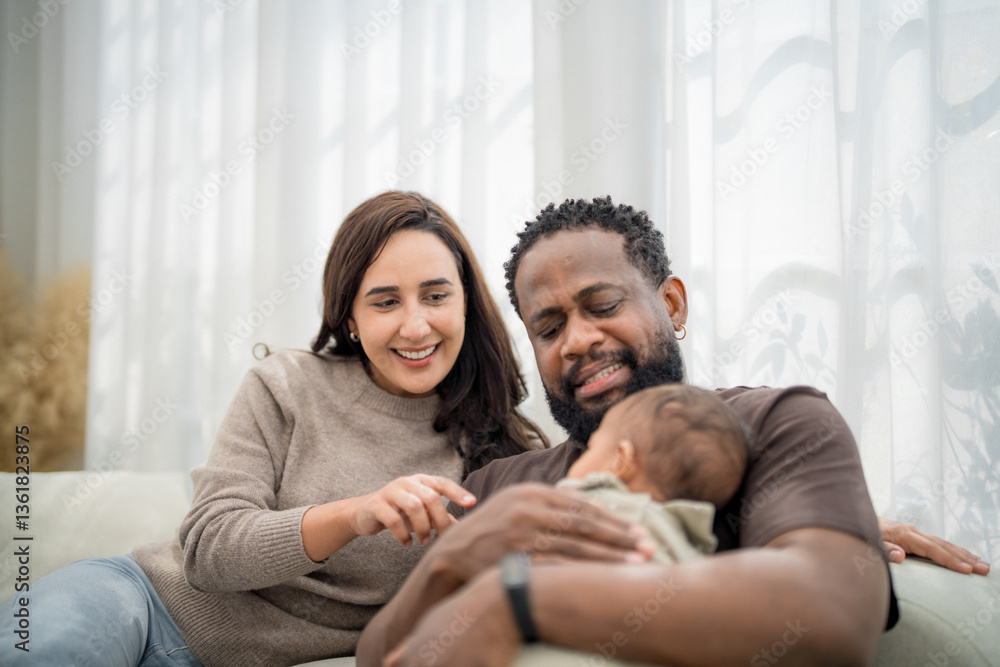 Joyful family moment captured indoors with parents lovingly interacting with their baby in a cozy living room setting Joyful family moment captured indoors with parents lovingly interacting with their baby in a cozy living room setting