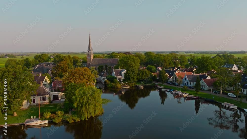 Aerial of a picturesque Dutch village, Broek in Waterland, on a sunny summer morning. Wooden houses, meadows, a small lake, and a church create a charming rural scene. Captured in 4K with a drone Aerial of a picturesque Dutch village, Broek in Waterland, on a sunny summer morning. Wooden houses, meadows, a small lake, and a church create a charming rural scene. Captured in 4K with a drone