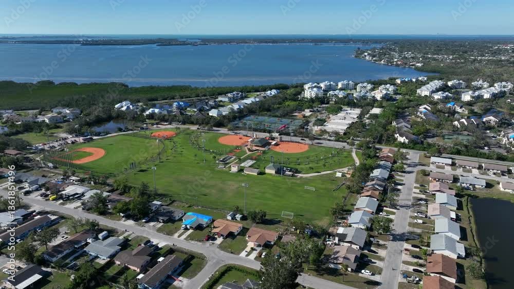 Baseball Court Sport Field of Bradenton, Florida. Aerial wide shot. Manatee High School Baseball, USA. Sunny day with blue sky and bay water in background. Top down. Baseball Court Sport Field of Bradenton, Florida. Aerial wide shot. Manatee High School Baseball, USA. Sunny day with blue sky and bay water in background. Top down.