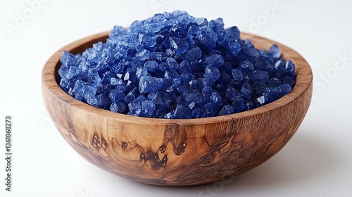 a wooden bowl filled with blue vitriol also known as copper sulfate the vibrant blue crystals contrast sharply with the wooden bowl,surface against a plain white background
