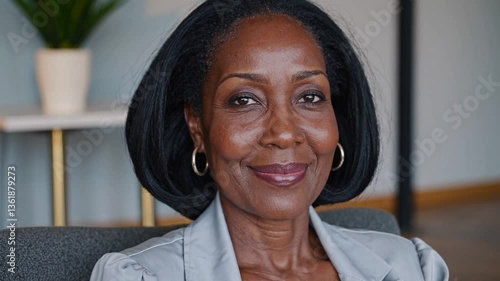 calm smiling middle-aged black woman in her 40s or 50s, smart casual, sofa