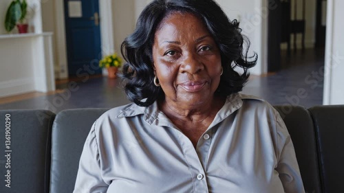 overweight black woman in her 60s with wavy hair waits for her turn in a waiting room, handheld shot