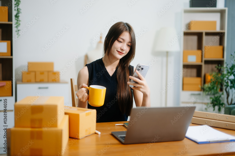 Young business owner woman prepare parcel box and standing check online orders for deliver Young business owner woman prepare parcel box and standing check online orders for deliver