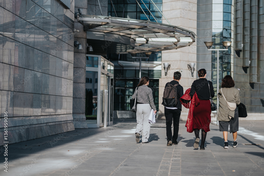 Obraz premium A diverse group of business people walking together past a contemporary office building, symbolizing teamwork, collaboration, and success in a corporate setting.