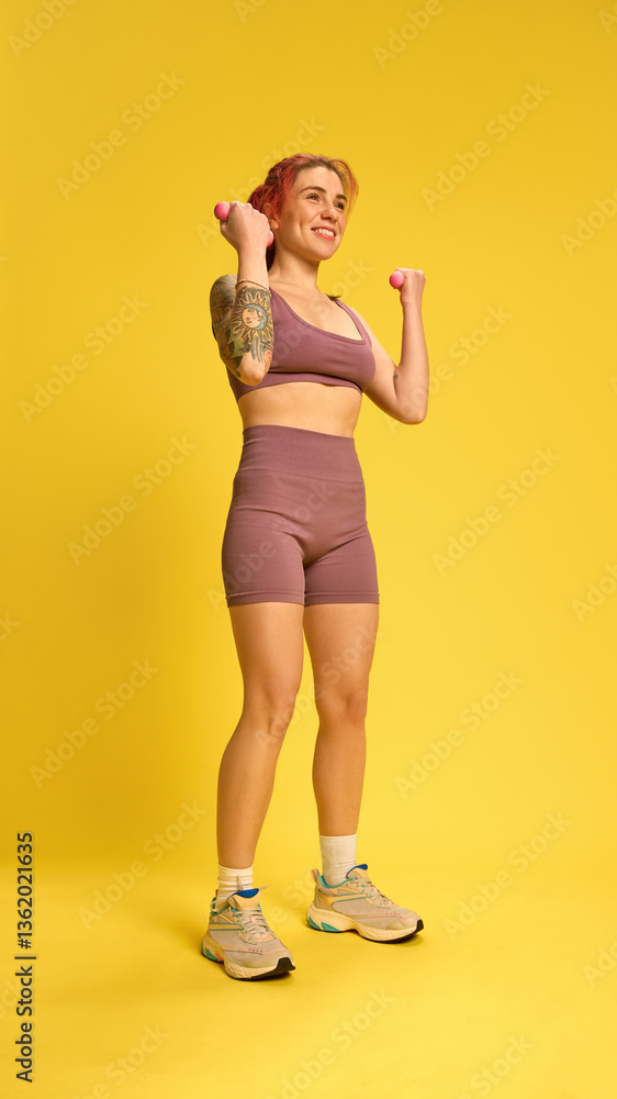 Smiling woman lifting dumbbells, dressed in soft purple activewear, training shoulders and arms with joy and confidence. Concept of strength, wellness, workout, sport equipment, positive energy. Smiling woman lifting dumbbells, dressed in soft purple activewear, training shoulders and arms with joy and confidence. Concept of strength, wellness, workout, sport equipment, positive energy.
