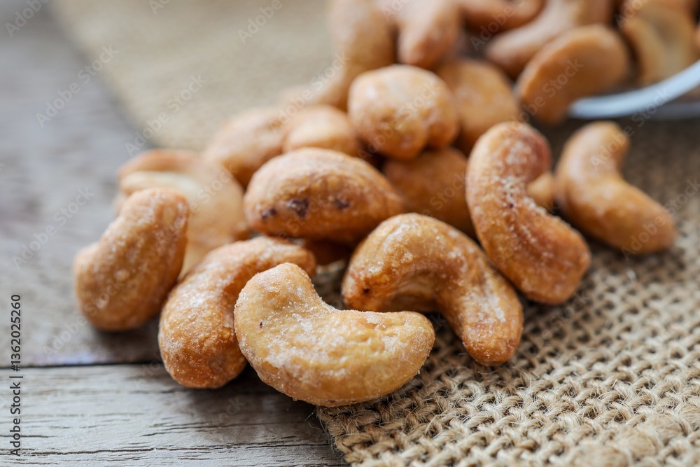 Obraz premium Close up of Salted cashew nuts on wooden background