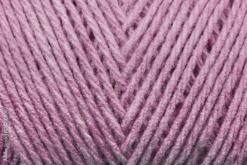 A close-up texture shot of pink yarn with diagonal stripes