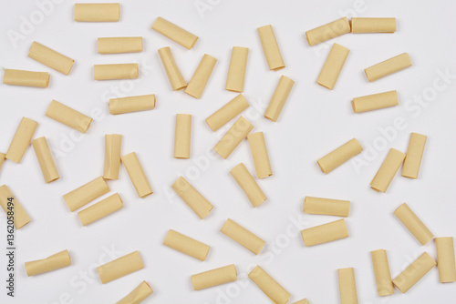 Scattered brown paper pieces are flat layed on a white background