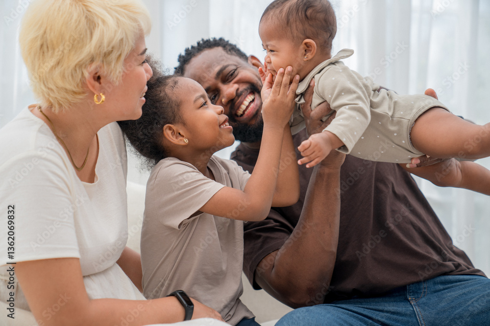 Fototapeta premium Happy family enjoying playful moments together in a bright living room during the day