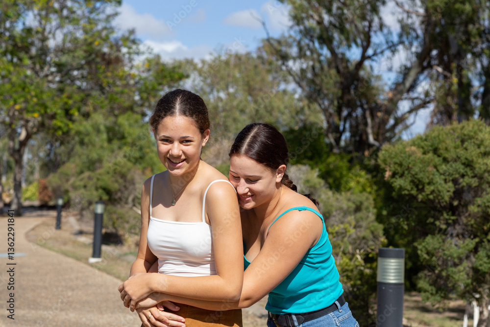 young women with arms around each other outdoors young women with arms around each other outdoors