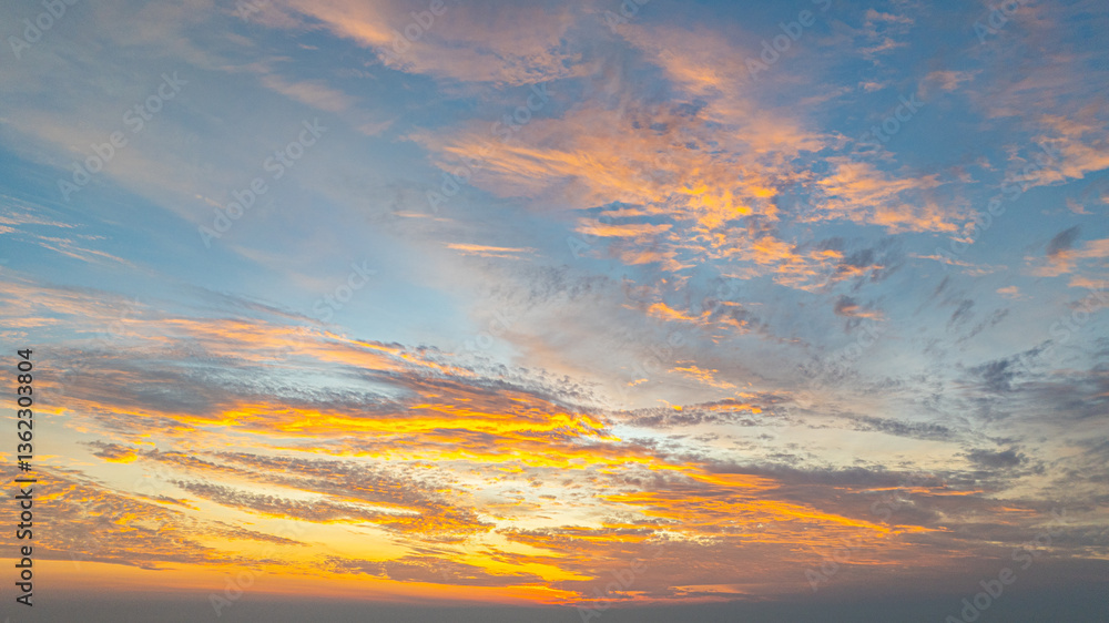 Fototapeta premium Aerial view A breathtaking view of a coastal city at sunset, with golden hues illuminating the sky and reflecting on the calm ocean. Small islands and boats are visible in the distance.