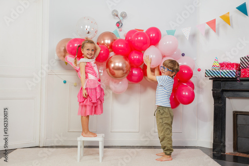 Obraz na płótnie Happy kids, boy and girl hang pink balloons for fun bday party w salonie