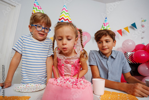 Obraz na płótnie Cute girl with brothers blowing out candles on her bday cake w salonie