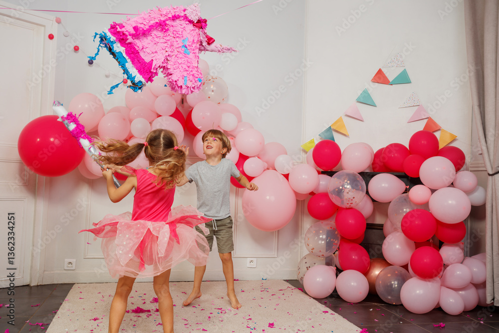 Dynamic image of small kids try to break unicorn pinata at party