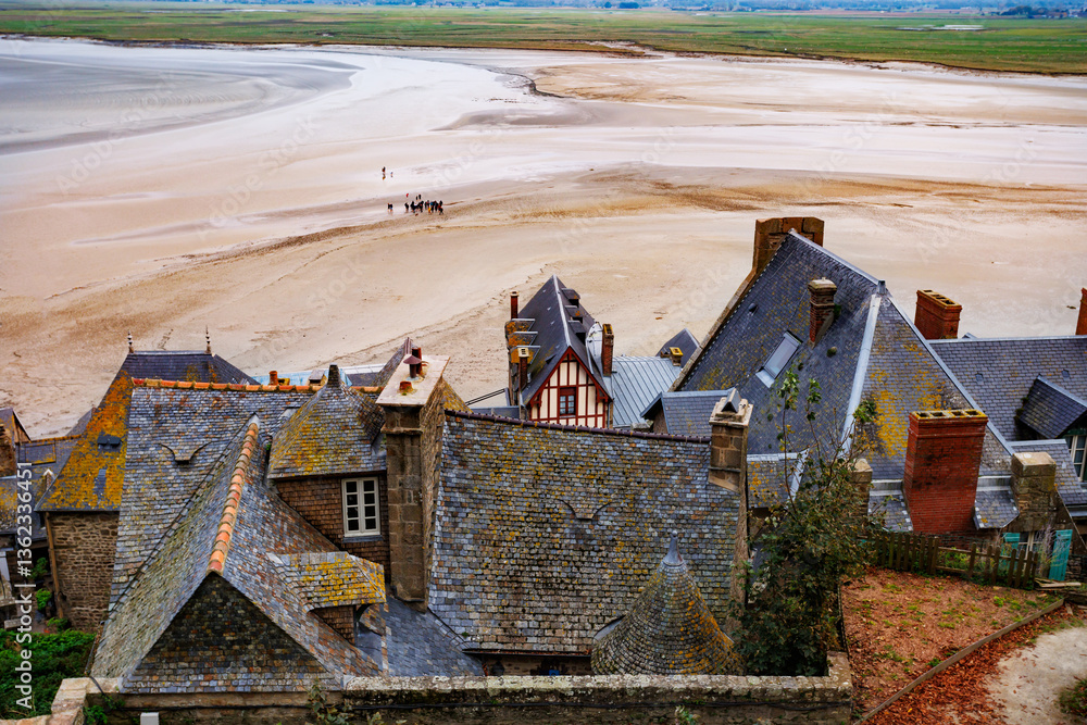Historic roofs of Mont Saint Michel and beach create scenic view