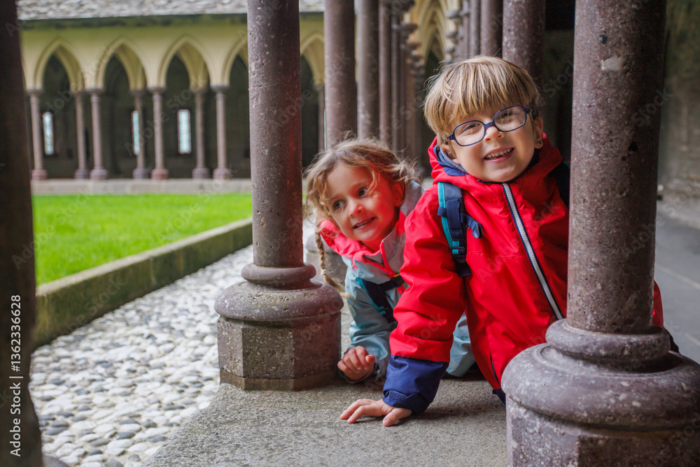 Playful kids enjoy historic castle with happy smiles, France