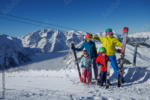 Obraz na płótnie A family with kids poses happily on snowy slopes in ski gear w salonie