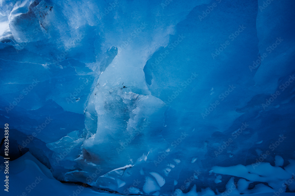 A close-up of sparkling deep blue ice, icy glacier cave part