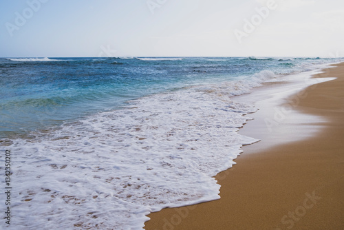 Beach and surf along Oahu's wild North Shore, waves breaking on the sand. photo