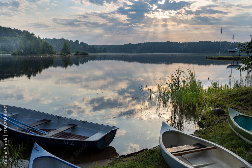 Obraz premium A group of small boats are sitting on the shore of a lake
