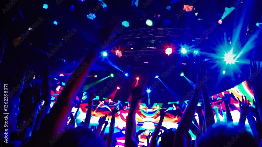 Vibrant concert scene with colorful lights and crowd from a low-angle, capturing the energy and excitement of a live music video performance. Vibrant concert scene with colorful lights and crowd from a low-angle, capturing the energy and excitement of a live music video performance.
