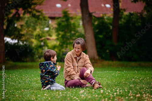 Smiling Parent and Child Sitting Together in Park