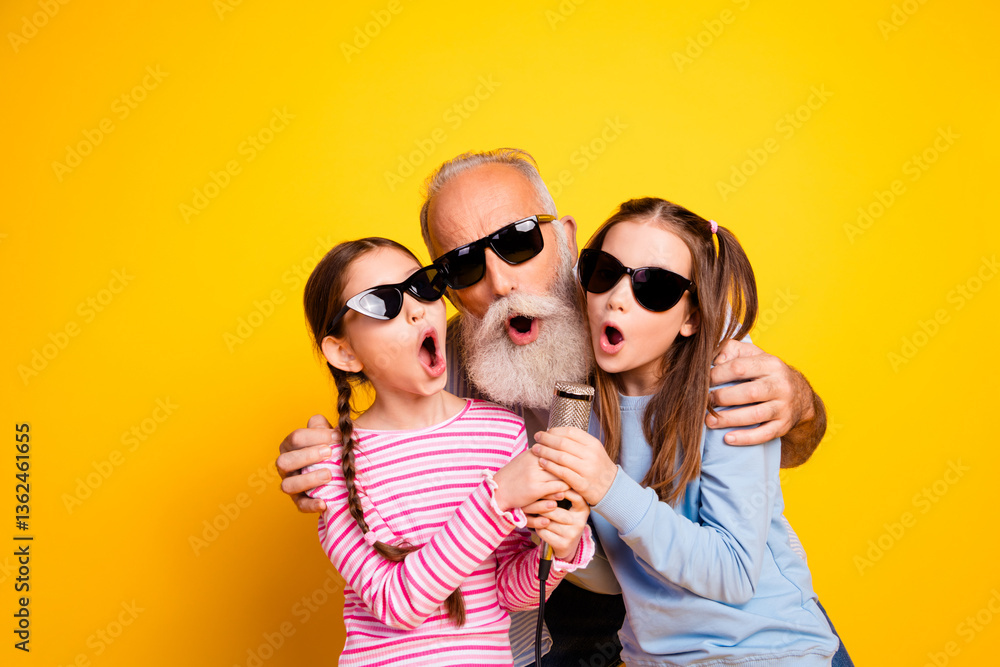 Obraz premium Joyful Three Generational Portrait with Bright Yellow Background Captures Family Bonding and Celebration of Togetherness