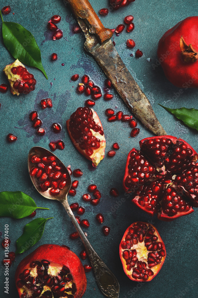 Juicy pomegranate grains in a bowl and in a spoon. On a concrete background. Close up. Juicy pomegranate grains in a bowl and in a spoon. On a concrete background. Close up.