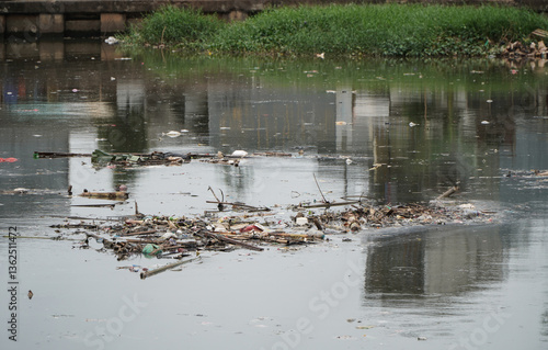 Polluted Jakarta River Surrounded by Pile of Trash and Litter Reflecting Urban Environment